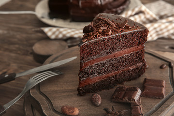Piece of delicious chocolate cake on board