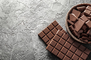 Composition with tasty milk chocolate on grey textured background