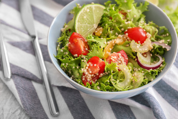 Bowl with quinoa salad on table, closeup