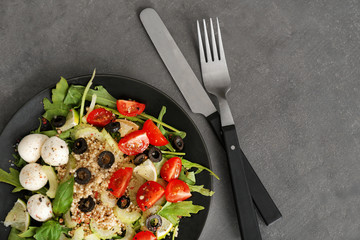 Plate with quinoa salad on grey background