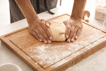 Man kneading dough on table
