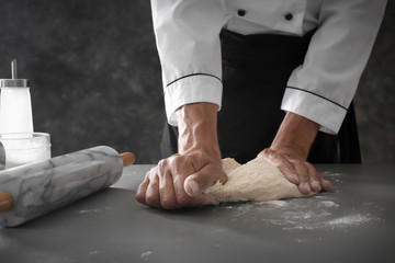 Man kneading dough in kitchen