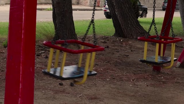 Altalena dondola nel vento. Parco giochi per bambini. Prato verde ed aria aperta