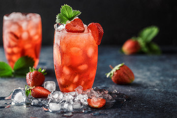 Frischer Erdbeercocktail. Frischer Sommercocktail mit Erdbeeren und Eiswürfeln. Glas Erdbeersodagetränk auf dunklem Hintergrund.