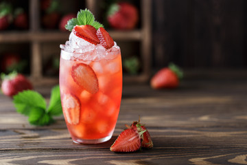 Frischer Erdbeercocktail. Frischer Sommercocktail mit Erdbeeren und Eiswürfeln. Glas Erdbeersodagetränk auf dunklem Hintergrund.