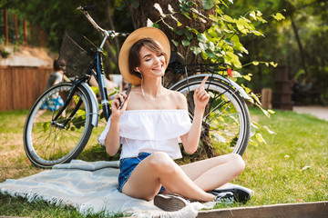 Smiling young girl listening to music with mobile phone