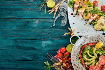 Food. A set of delicious salad with avocado and vegetables. On a wooden background. Top view. Copy space.