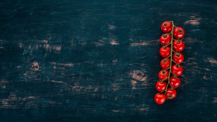 Cherry tomatoes on a twig. On a wooden background. Top view. Copy space.