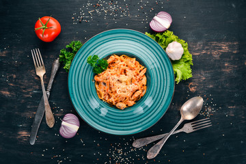 Pasta with chicken and mushrooms. Italian cuisine. On a wooden background. Top view. Copy space.