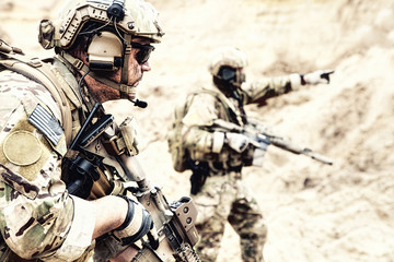 US special operations forces fighters armed with assault rifle, in opscore helmet, radio tactical...
