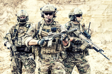 Group portrait of US army elite members, private military company servicemen, anti terrorist squad fighters standing together with guns. Brothers in arms, war conflict combatants, soldiers of fortune - obrazy, fototapety, plakaty
