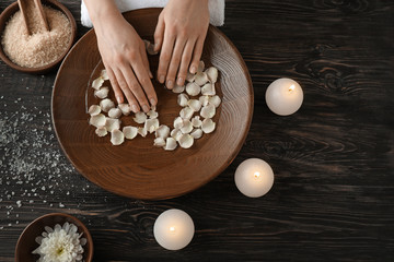 Young woman undergoing spa manicure treatment in beauty salon