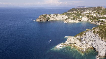 Aerial view of the beach and the small harbor of Cala Feola on the island of Ponza, in Italy. There are many boats and motorboats of tourists anchored in the bay and sheltered in the mountains.