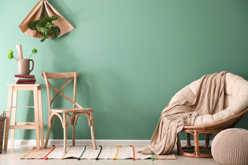 Stylish furniture near color wall in room interior