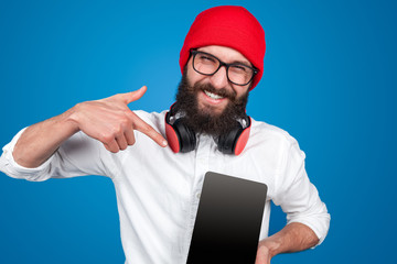 Man in headphones pointing at tablet