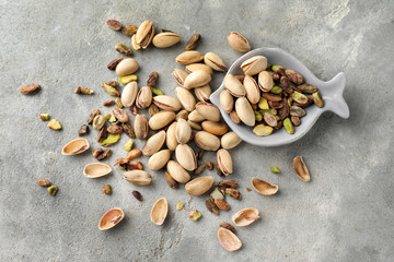 Tasty pistachio nuts on grey background
