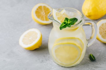 Homemade refreshing summer lemonade drink with lemon slices, ginger and ice