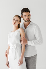 handsome man in linen clothes embracing girlfriend isolated on grey background