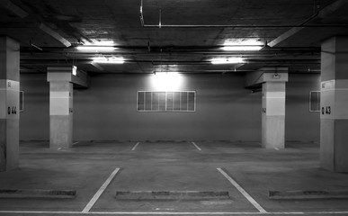 Perspective view of empty indoor car parking lot at the mall. Underground concrete parking lot with open light. Feel sad and lonely concept. Q43 and Q44 car parking lot at B2 block