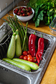 Fototapeta washing fresh vegetables in kitchen