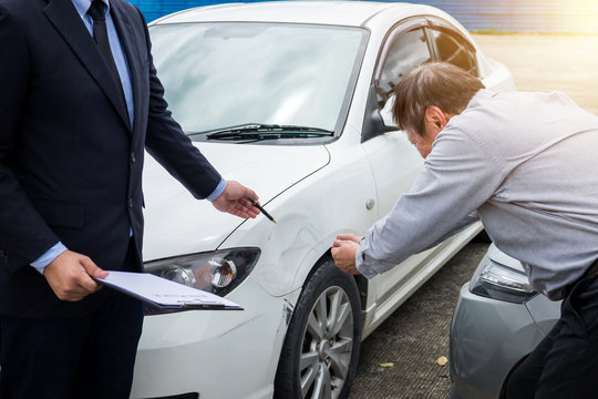 Insurance Agent examine Damaged Car and filing Report Claim Form after accident, Traffic Accident and insurance concept