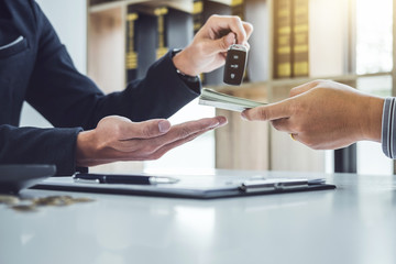 Salesman send key to customer after good deal agreement and receive money, successful car loan...