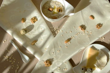 Served breakfast with oatmeal, eggs, cheese and nuts in a light key. Healthy food.