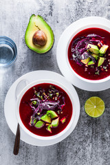raw raw soup of fresh red vegetables and avocado in a plate on the table. healthy summer detox diet