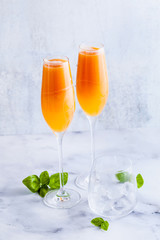 summer alcoholic fruit drink in glasses for champagne. on the marble table. with ice. refreshing cocktail