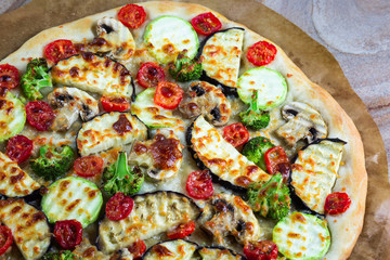 Homemade pizza with vegetables, natural dough on leaven. With zucchini, eggplant, cherry tomato, broccoli, mushrooms. The concept of a healthy diet. Vegetarian.