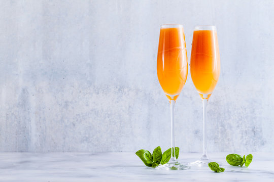 summer alcoholic fruit drink in glasses for champagne. on the marble table. with ice. refreshing cocktail