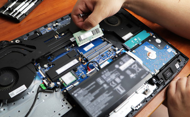The technician hold the screwdriver for repairing the computer, the concept of computer hardware,...