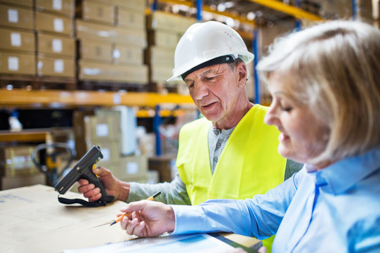 Senior woman manager and man worker working in a warehouse.