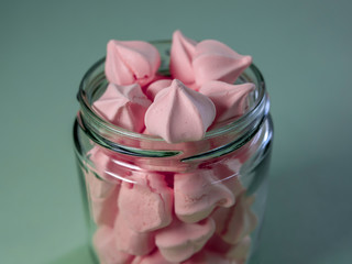 Colorful meringues in a transparent jar