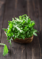 Obraz na płótnie Canvas Fresh green arugula in bowl on table. Arugula rucola for salad. Close up of fresh green healthy food. Diet concept.
