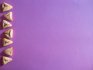 Hamantash, Ozen Aman - traditional Jewish cuisine, used during the Jewish holiday of Purim, top view on purple background