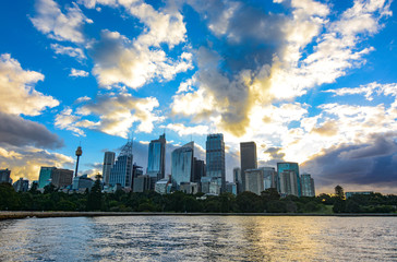 Amazing sunset over the Sydney central business district city skyline seen across the harbor from the Botanic Gardens