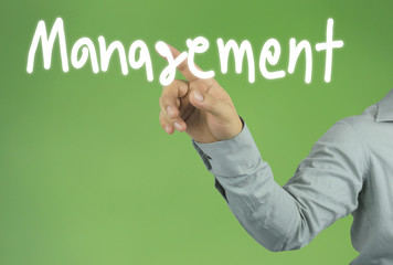 Hand of the businessman pointing to the Management text on green background and have copy space for design in your work concept.