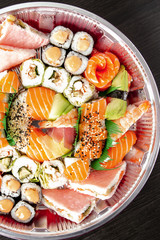 A set of sushi in a metal container on a black background. Top Vieux. Vertical shot.