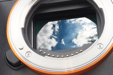 Dramatic blue sky with clouds open mirrorless camera, sensor replaced by an own photo, assambly