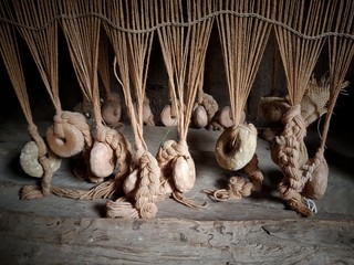 Lines of clay loom weights keep the threads taught on an replica Anglo-Saxon loom.