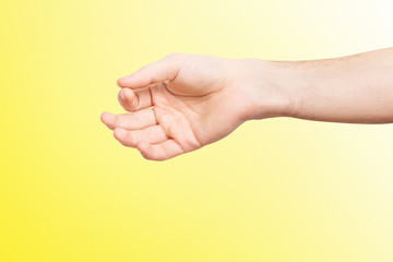 Naklejka premium Closeup isolated male hand holding invisible object at yellow background.