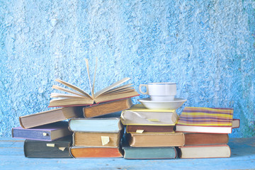 Open book on a stack of books and a cup of coffee, reading, learning, education concept, copy space