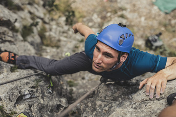 Male Alpinist Climbing a Rock