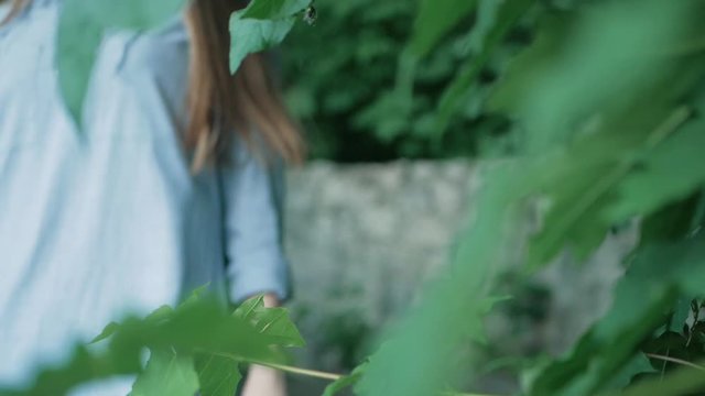 a woman comes down the stairs in the park. focus on green leaves. summer vacation