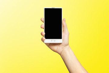 Mockup of female hand holding frameless cell phone with black screen isolated at yellow background.