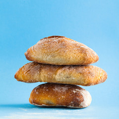 a pile of fresh Italian bread on blue background
