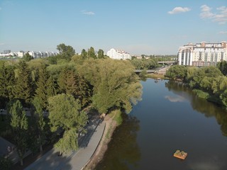Fototapeta na wymiar flight over the river in a city park among trees