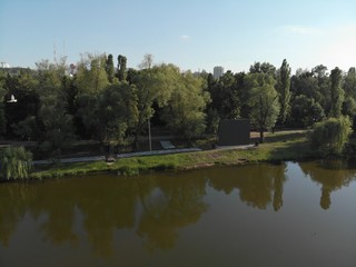 flight over the river in a city park among trees