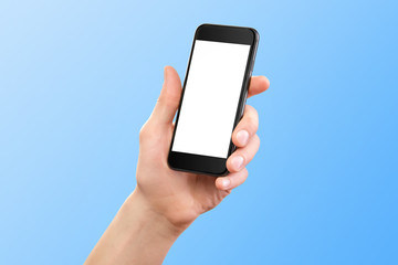 Mockup of male hand holding black cellphone isolated at blue background.
